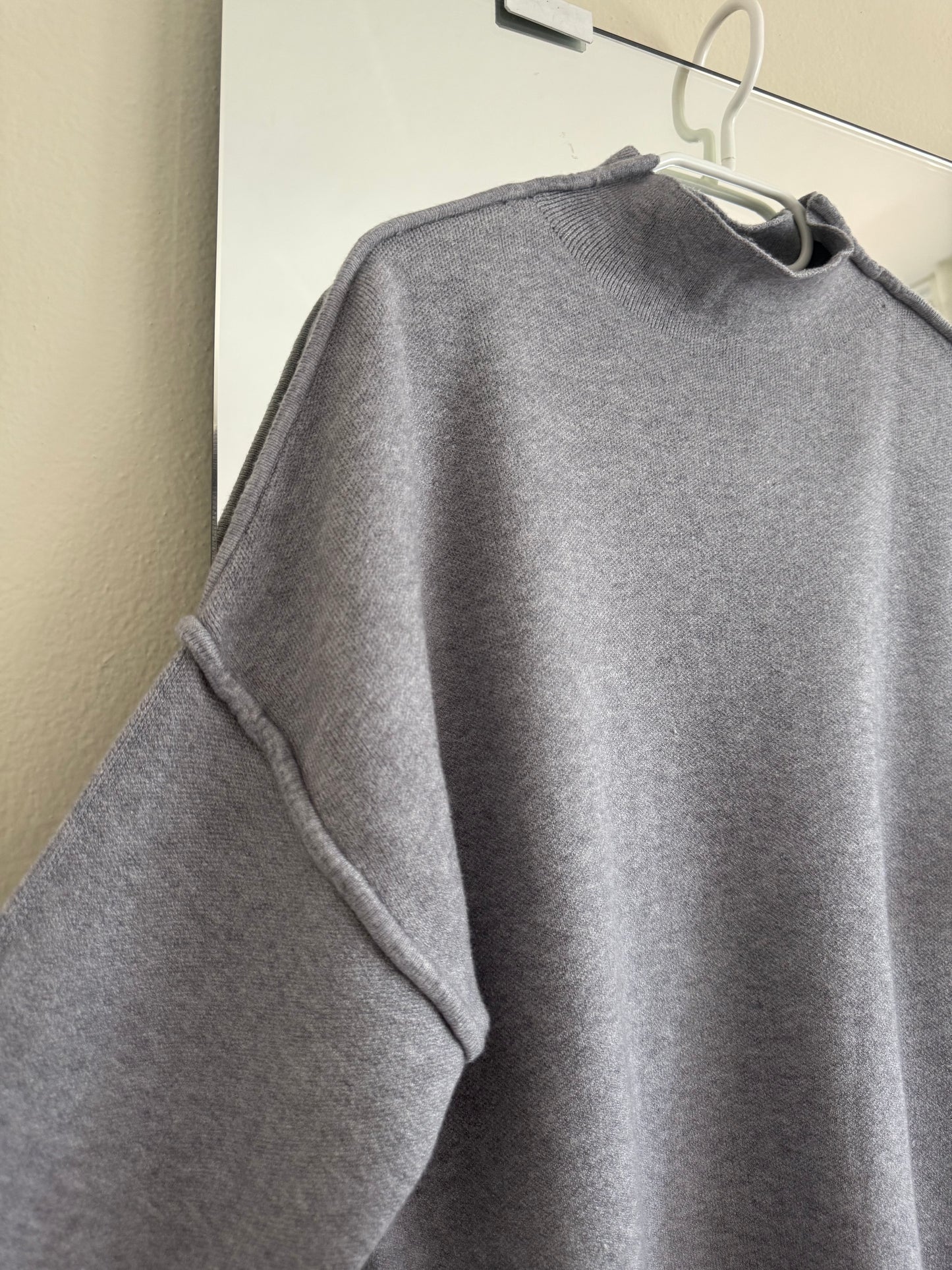 Maglione con cuciture in vista e manica a tre quarti